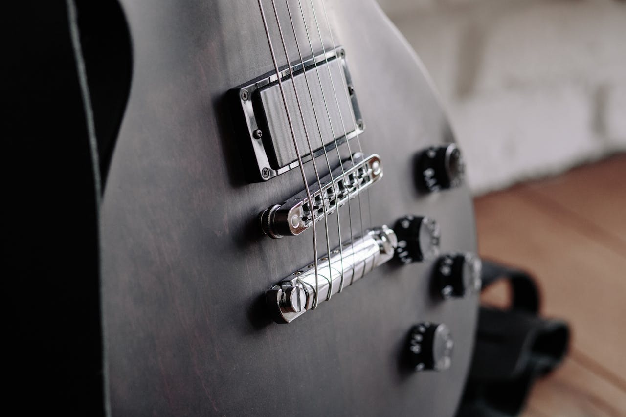 Detailed close-up of electric guitar strings with focus on the bridge. Perfect for music enthusiasts.